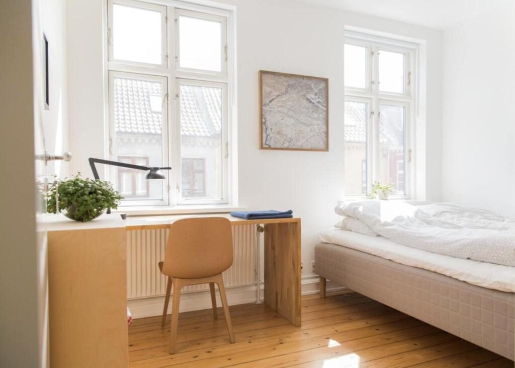 Bright Scandinavian guest room with a desk and queen bed